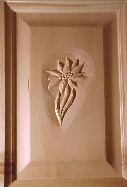 Le banc fustier : Edelweiss sculpte sur porte en arolle